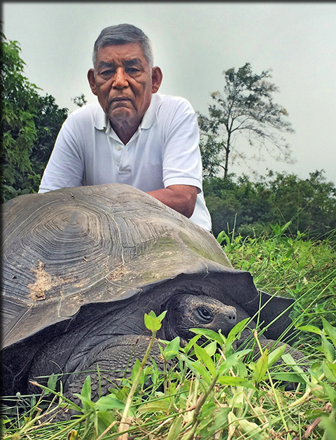 "Don Fausto" poses with a tortoise from the species named in his honor. Image credit: Washington Tapia