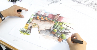 A designed landscape being drafted with visible hands.