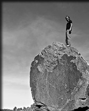 black and white image of raymond gutteriez standing on a rock