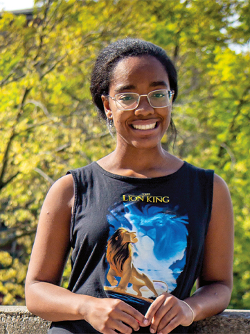 zaynab taveras wearking a lion king tank top. She is smiling