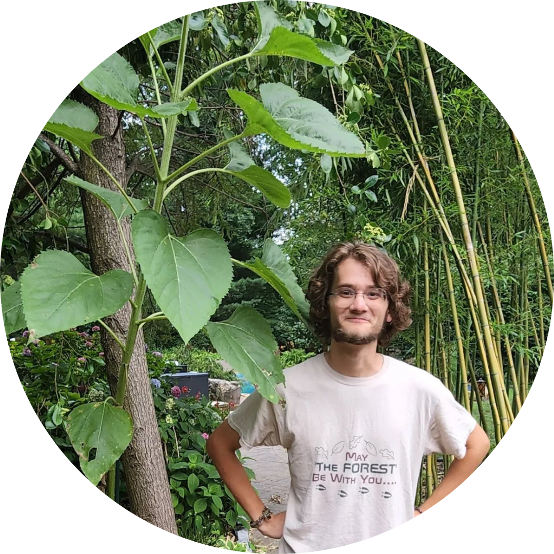 Carter smiling next to a tree