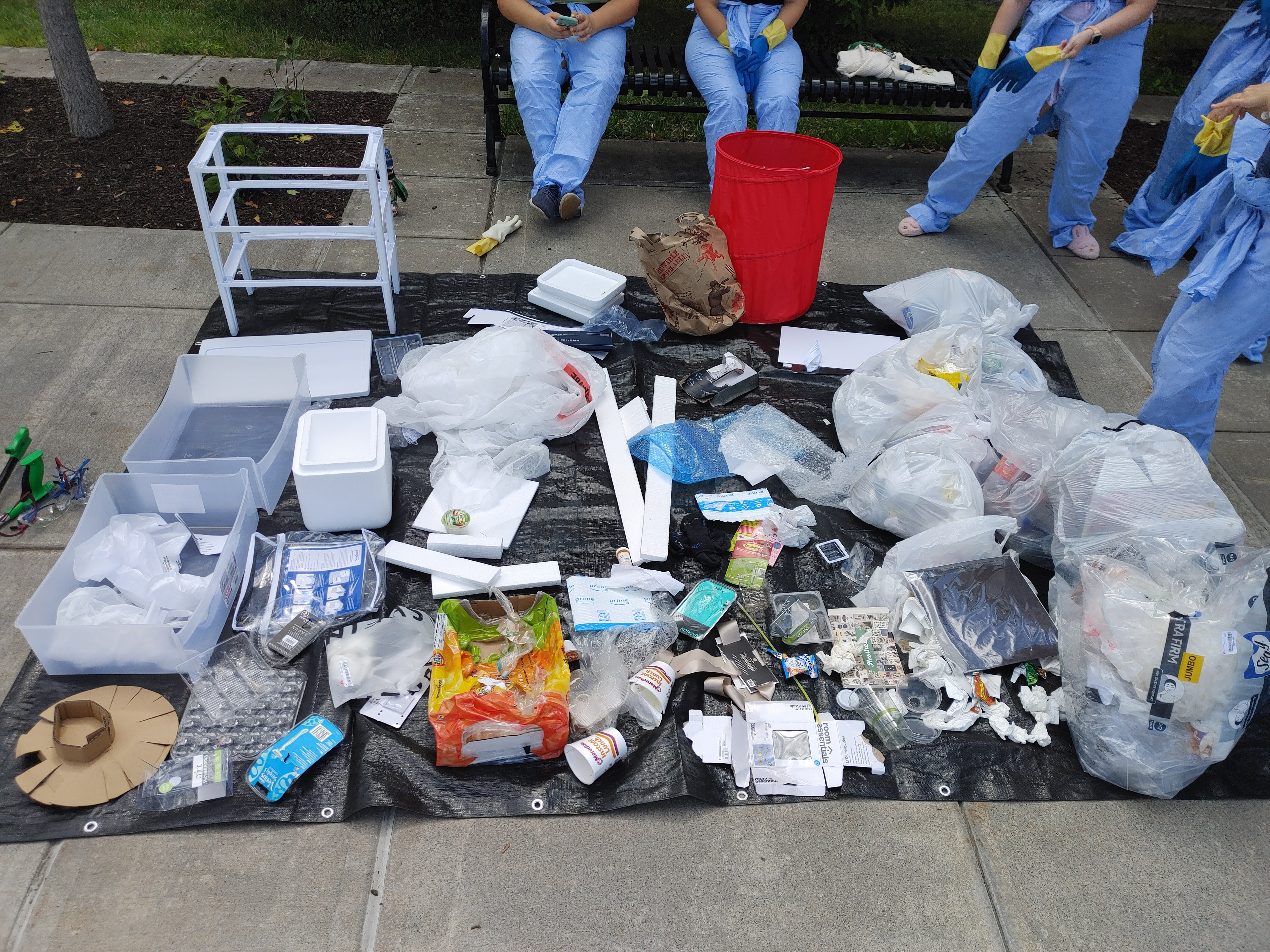 Items, mostly plastic, laid out on a tarp in a neat and orderly fashion