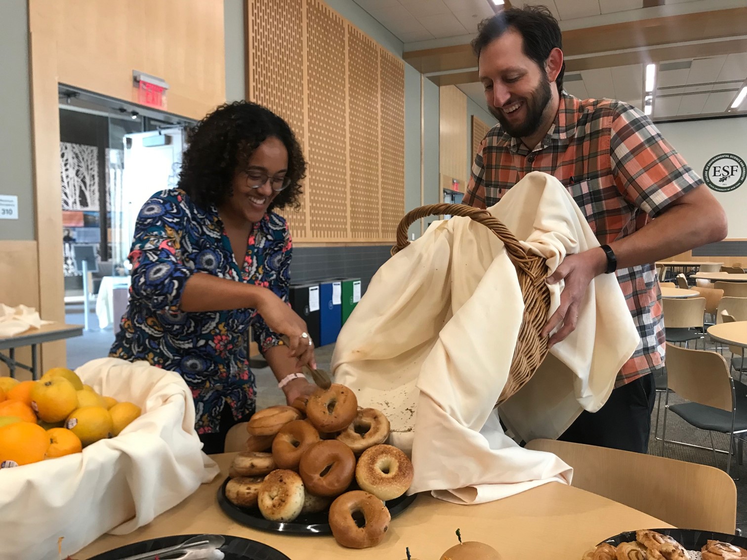 two people happily sort food for donation after an event