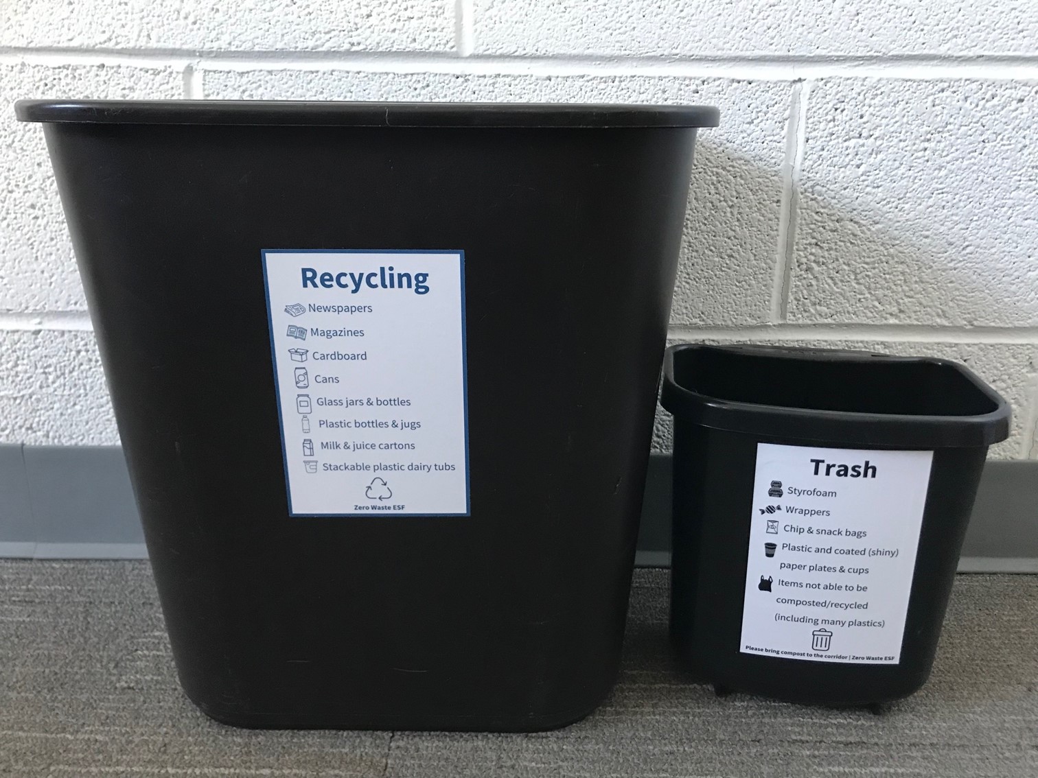 Standard recycling bin next to mini trash bin, both with educational signage
