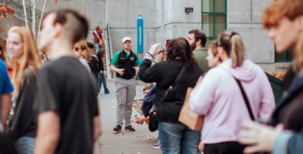 Photo of an admissions visit outside of Jahn Laboratory with passing students in the foreground.