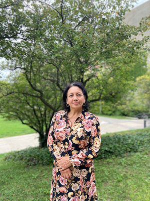 Mercy Borbor standing in front of a tree in a floral dress