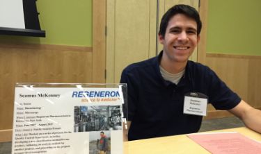 Man seated at a display table.