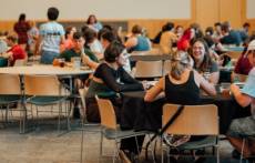 Students sitting at tables at an event.