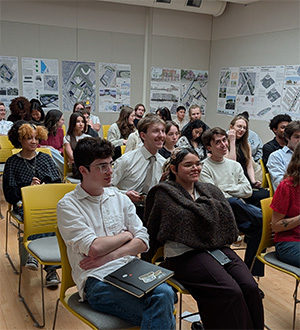 Students sitting next to each other. The wall content consists of studio work which has been deliberated upon for months in guidance from CCRD’s leadership.