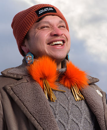 Abraham Francis wearing an orange hat and smiling