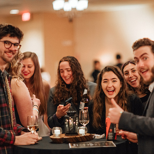 Attendees around a table at a past December Soiree.