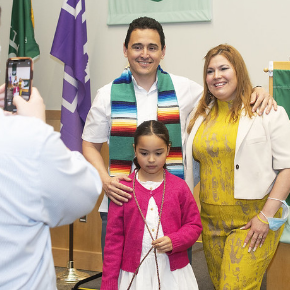 A family of a graduating student poses with a graduate.