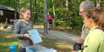 Student discussing her research at a table.