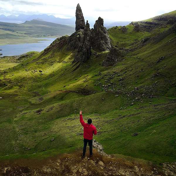 a guy in red jacket looking at the mountains