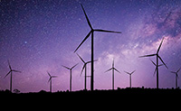 The sky is purple and dark outlines of wind turbines