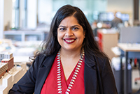 headshot of Shefali Sanghvi. She is wearing a red top and black jacket.