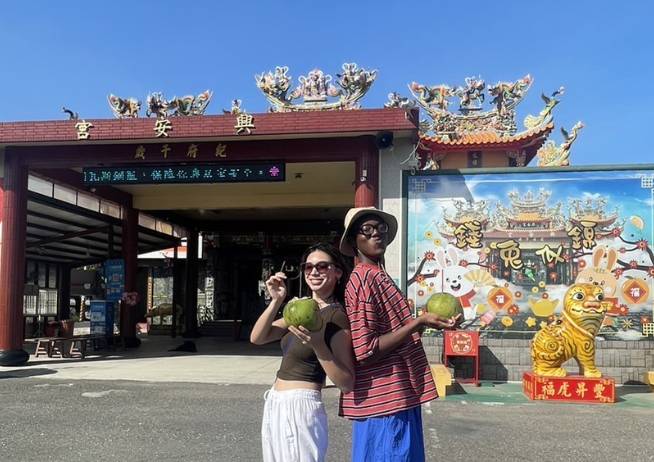 Two people standing outside a building abroad.