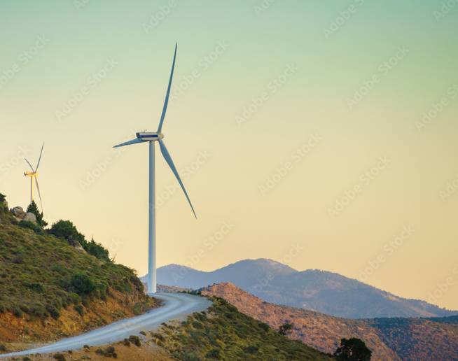 Windmills along a winding mountain ridge roadway.