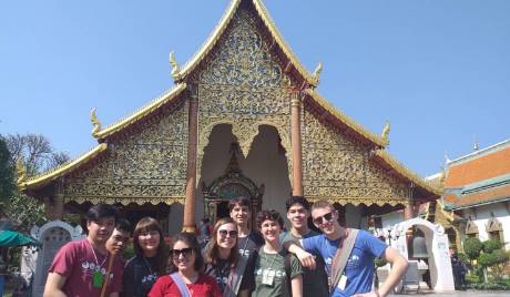 Group of students standing outside a temple in Thailand.