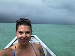 Mia glover taking a selfie in boat. There is water all around her