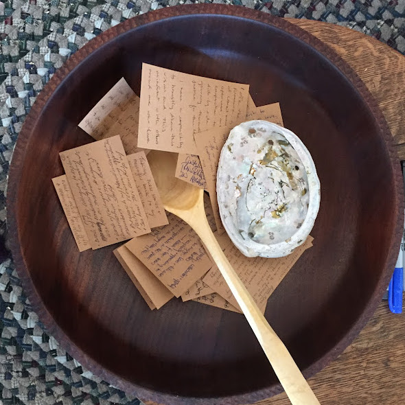 a wooden bowl with handwritten notes and a wooden spoon