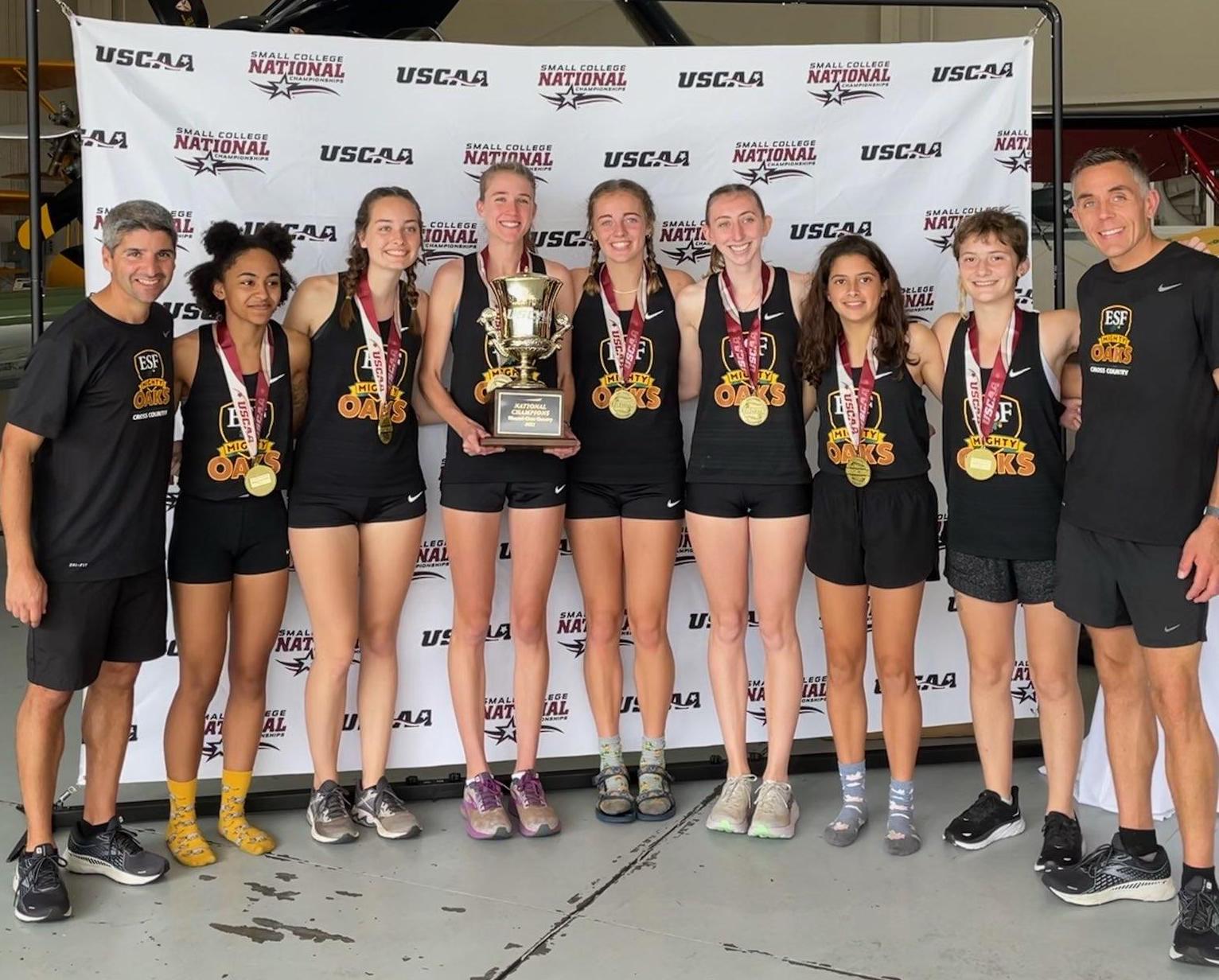 Women's cross country team with medals and cup after winning the USCAA titles