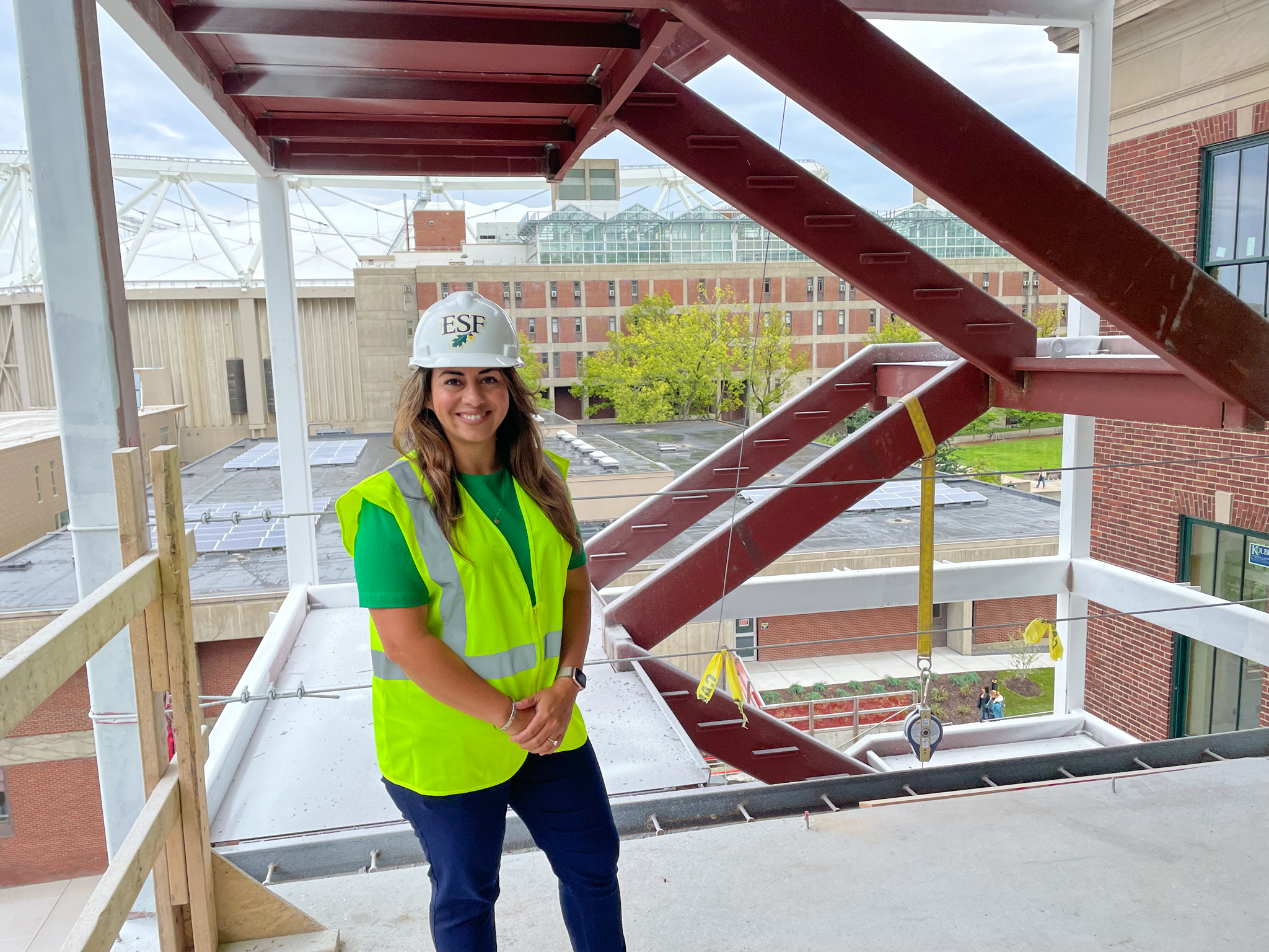 Diana Jaramillo wearing a white E S F hard hat and green jacket standing in Marshall Hall