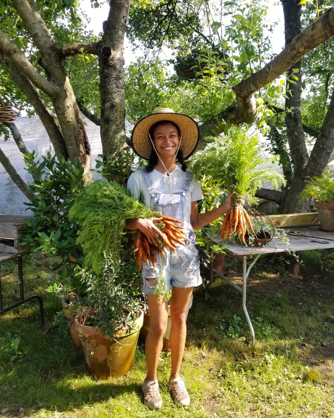 Kathryn McKenzie holding a bunch of carrots.