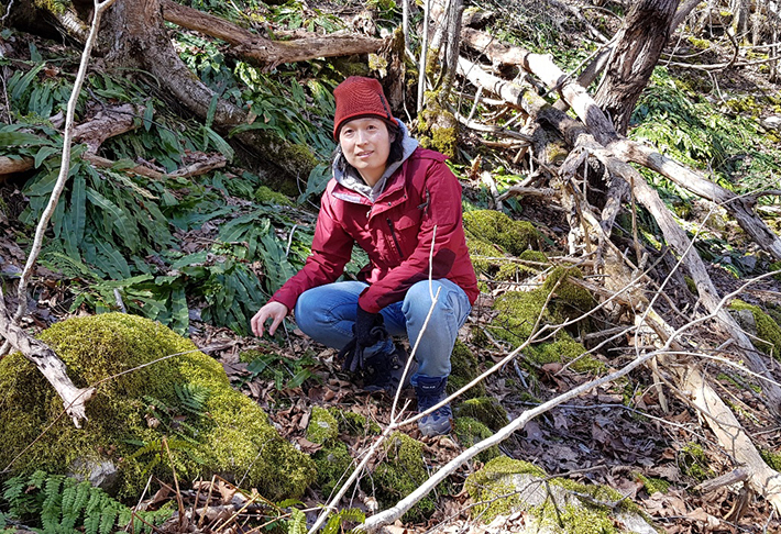 Namjoo heo in jeans, red jacket and red cap in a forest