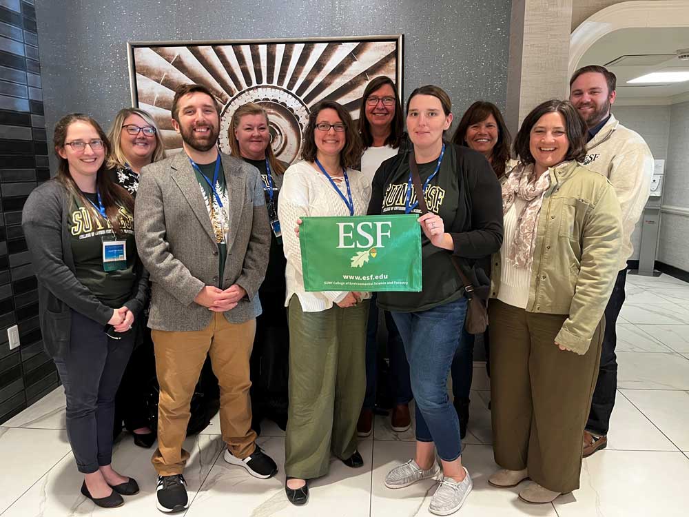 E S F office of research programs staff with E S F flag