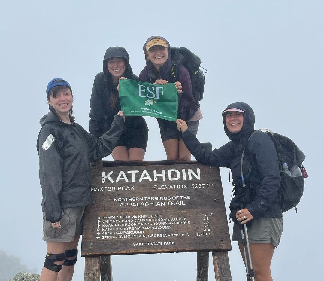 E S F Alumni holding E S F flag at Katahdin, northern terminus of the Appalachian Trail