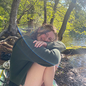 Woman in a green sweater looking at the camera. 