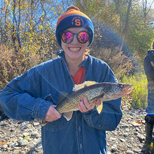 Woman wearing a SU hat and holding a fish. 