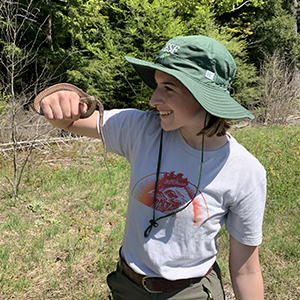 Woman wearing an ESF bowl hat and looking off into the distance. 