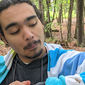 Man looking at a bug on his jacket. 