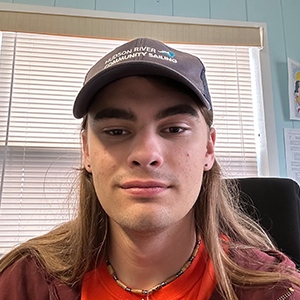 Man wearing a hat and red shirt. 