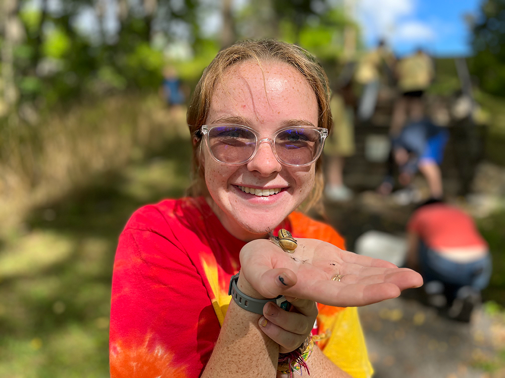 Woman wearing a red, orange and yellow tie-dye t-shirt 