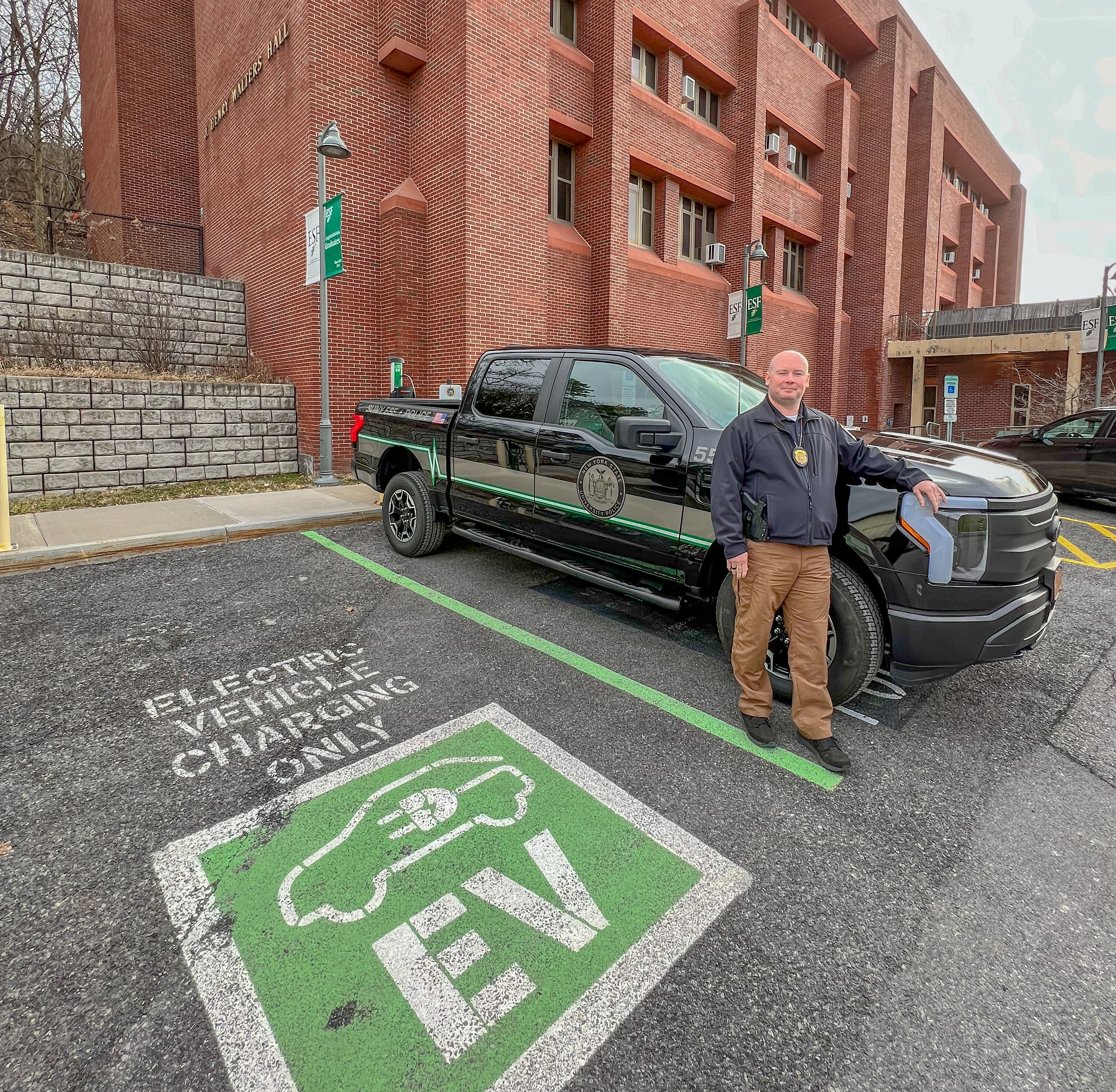 Chief Bob Dugan standing in front of the new electric vehicle truck. 