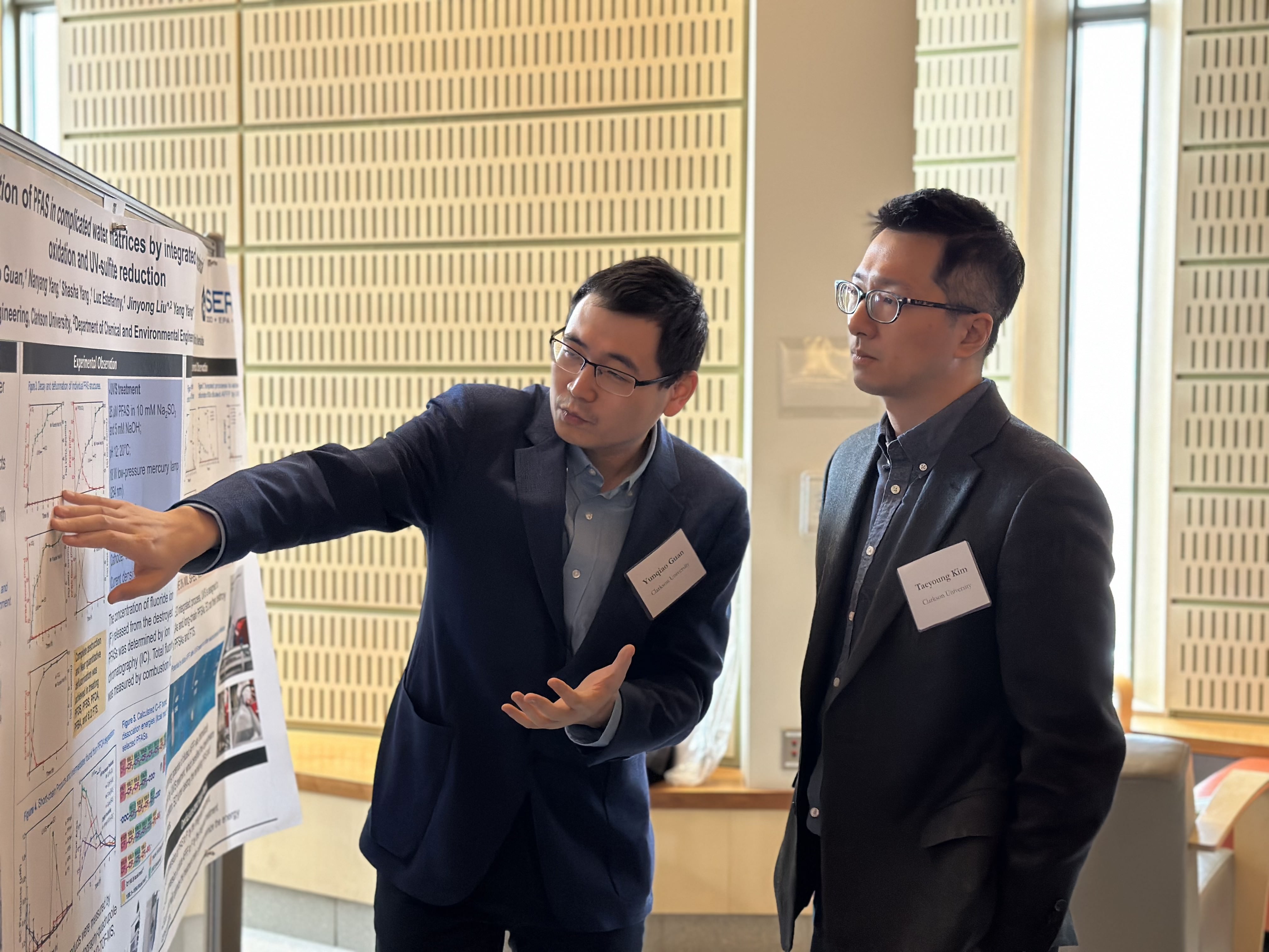 Two people looking at a science research poster.