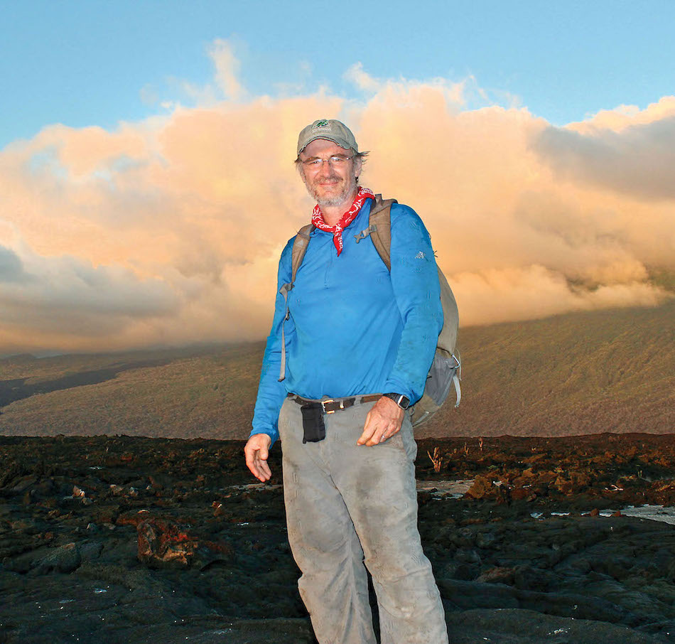 James Gibbs standing on mountain top with sunset behind him