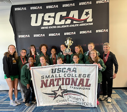 two rows of people pose with USCAA championship banner