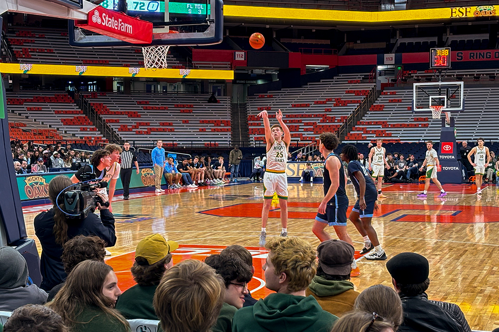 Basketball player in white uniform taking shot from foul line.