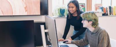 Two people working at a computer.