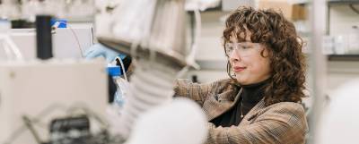 Person in safety glasses working at a specialized instrument.