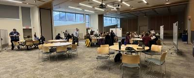 Faculty seated at tables during a workshop.