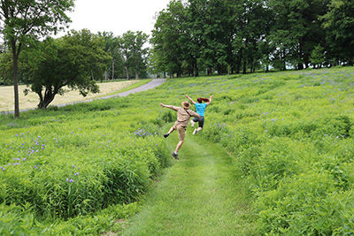 Sam Quinn and Lilly Kramer jumping through the fields