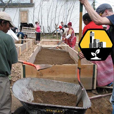 people filling up raised beds with soil