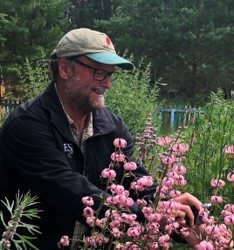 Don Leopold smiling. There are flowers around him