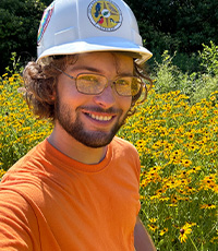 Jacob wearing a hard hat and orange tshirt