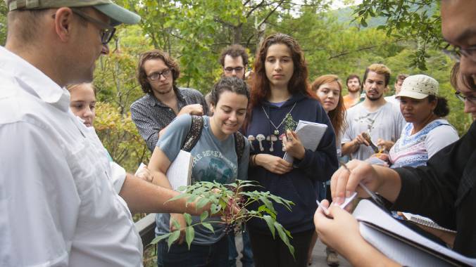 Students examining a plant sample in the field.